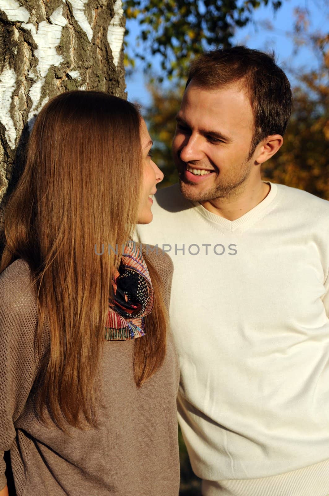 Young couple under a tree in autumn