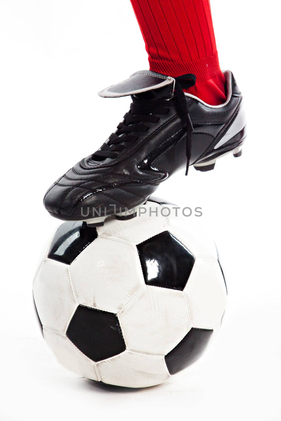 Foot in the red socks, and black shoes standing on a football