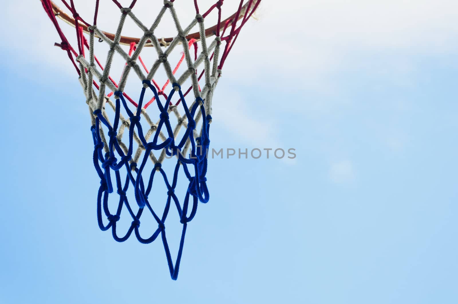 Close-up of basketball ring with net shot against blue sky