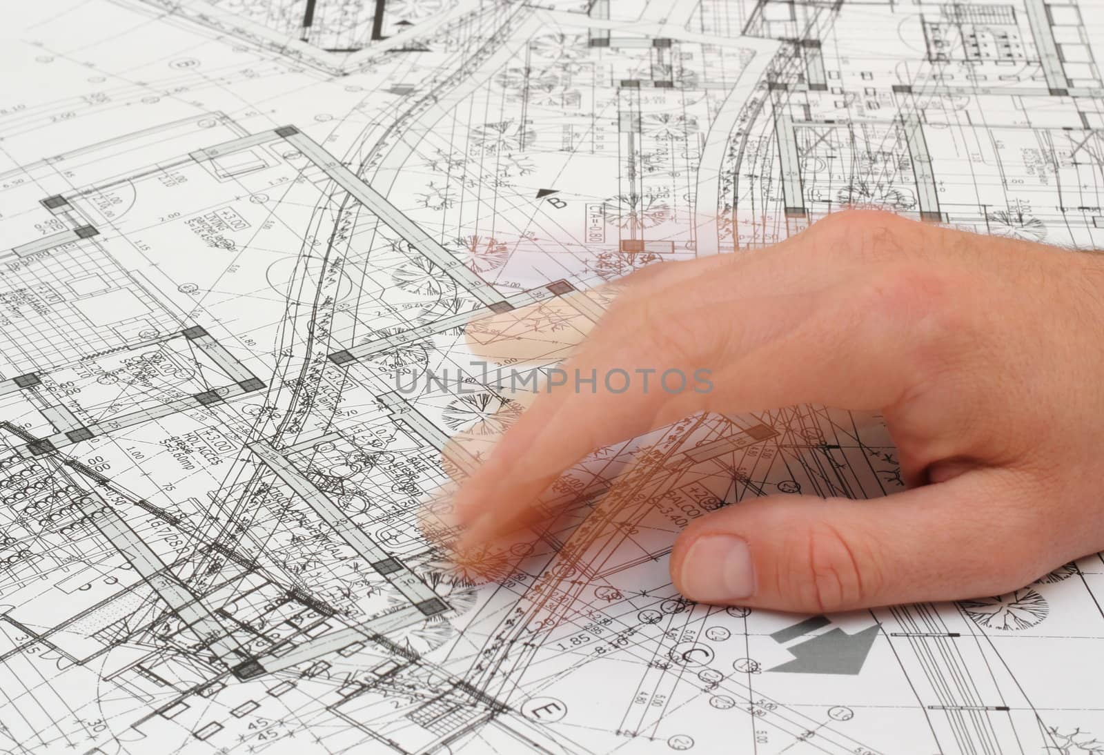 architect shaking his fingers as he searches a solution out of a very messy blueprint