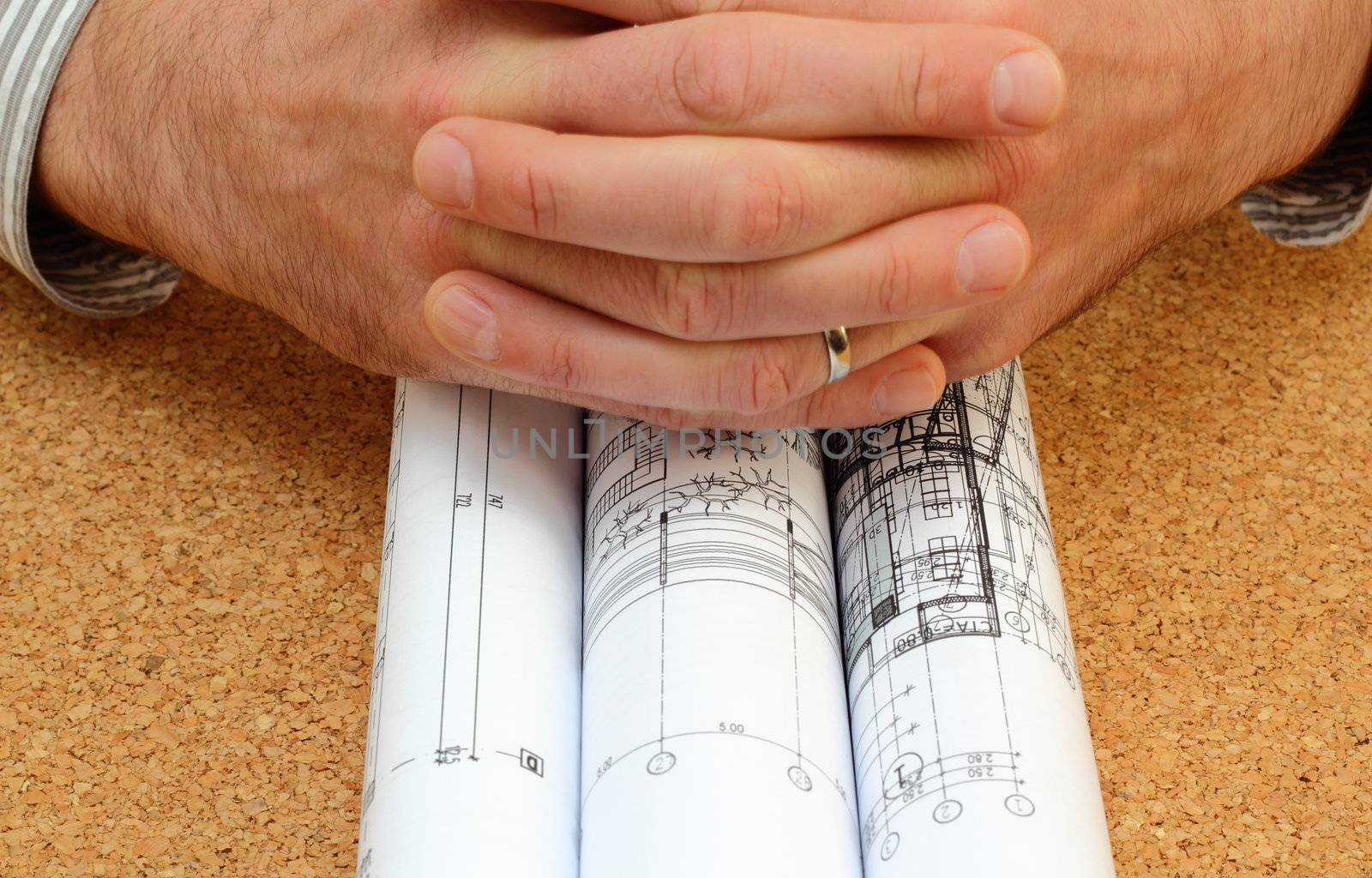 human hands over architectural work - rolled blueprints over the office