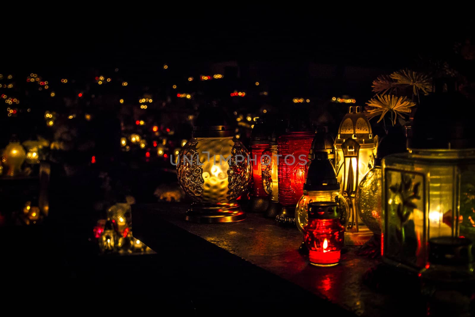 All Saints' Day at a cemetery in Poland - flowers and light candles to honor the memory of deceased relatives.