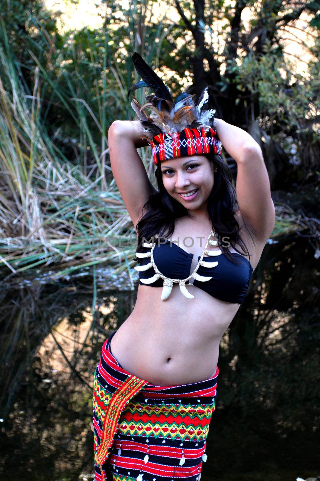 Native american woman posing next to a creek.