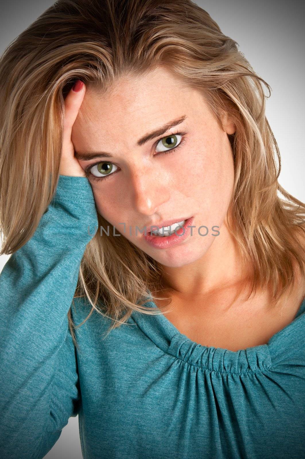 Woman suffering from an headache, holding her hands to the head. Vignetting on the corners.