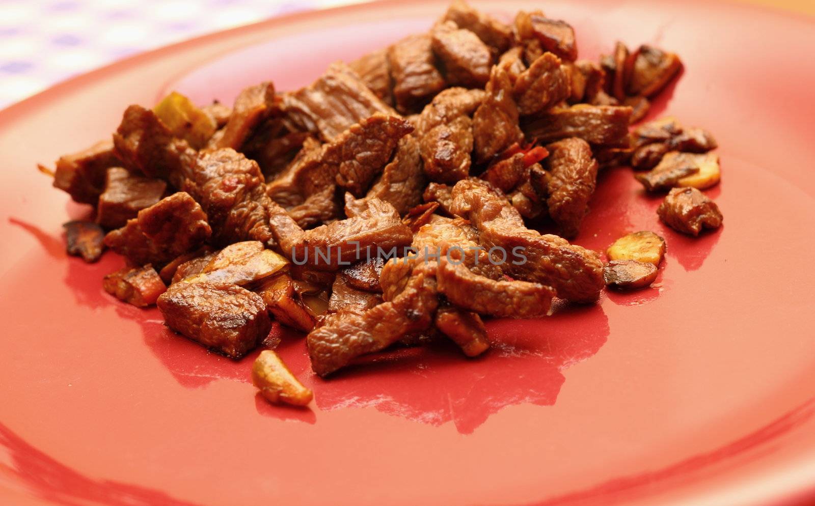fried beef slices on a red dish