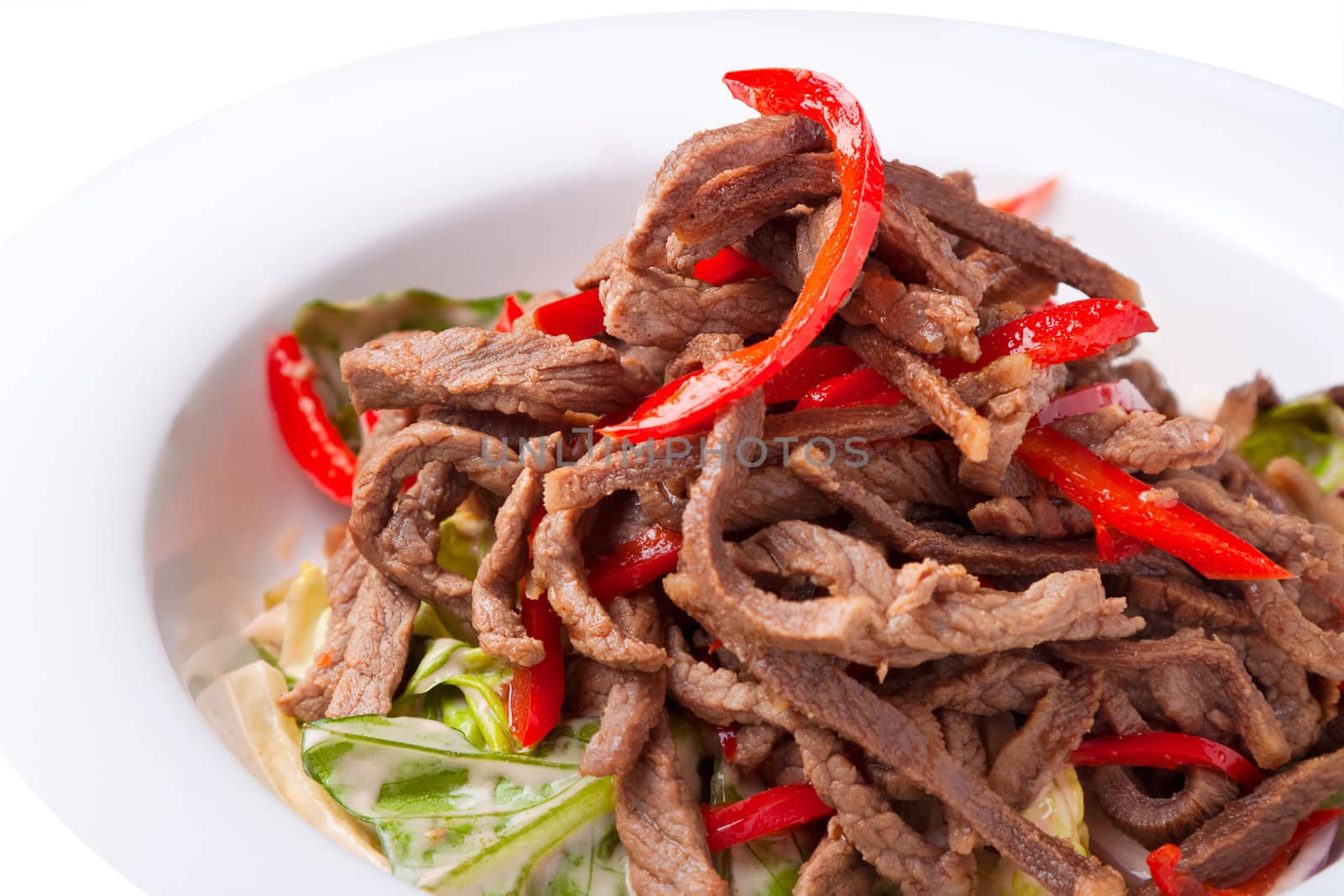 Salad of meat with red pepper on white plate close up