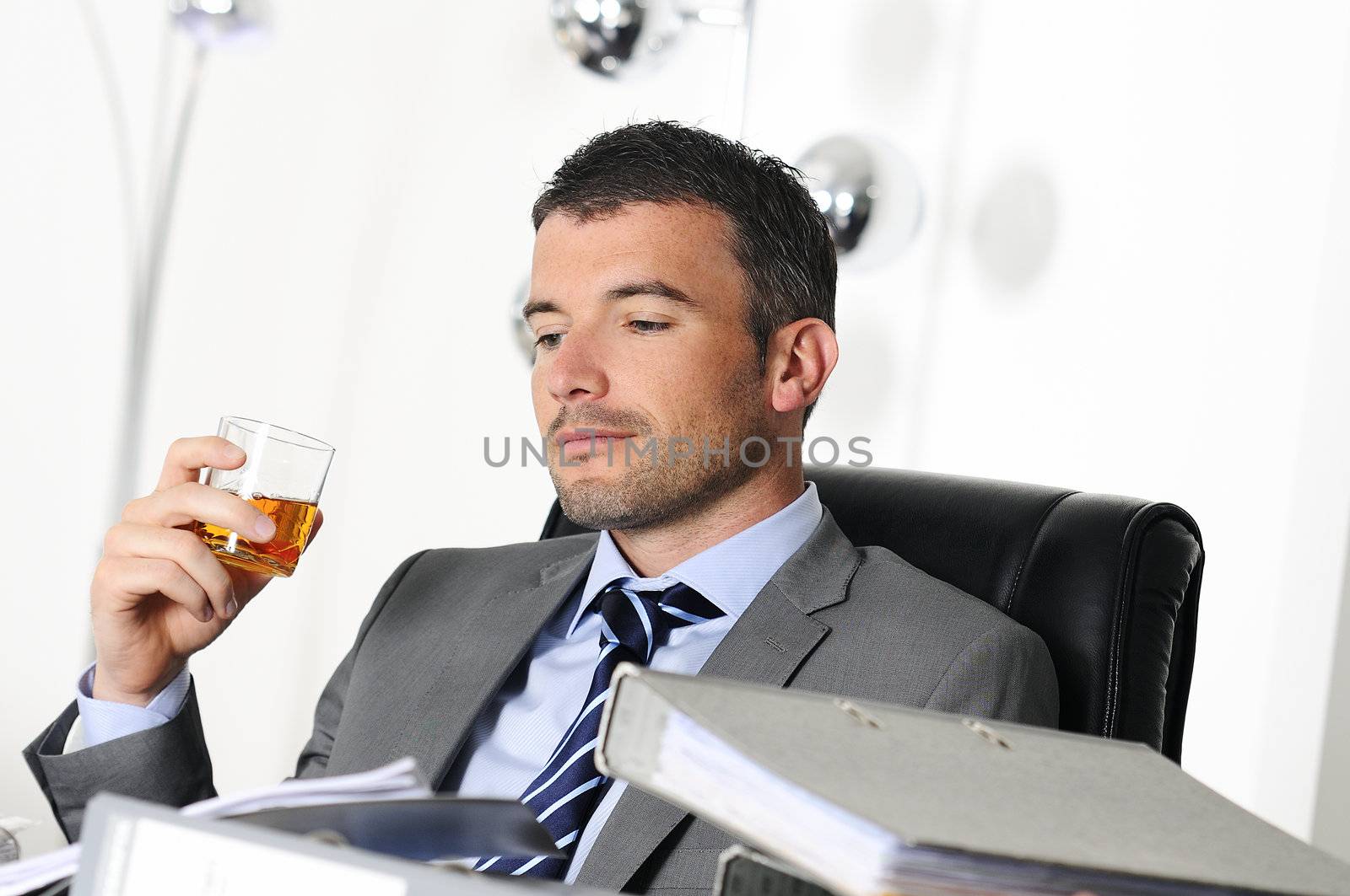 business man is drinking alchool at the office