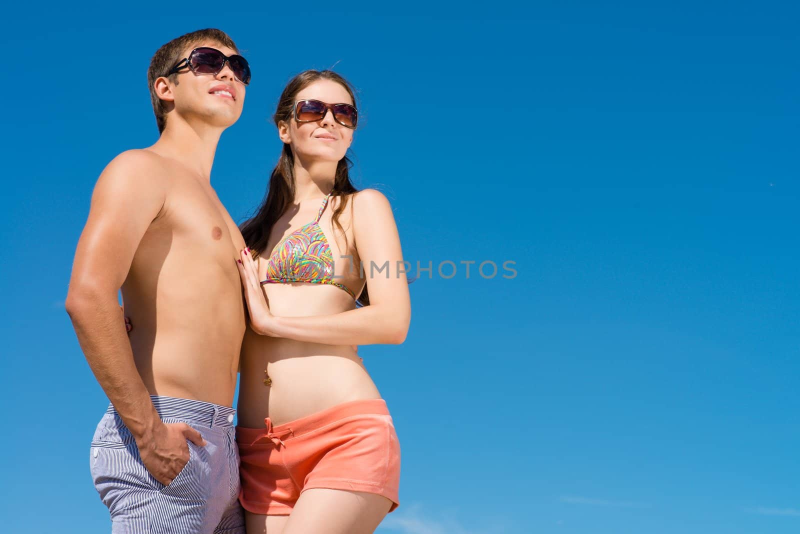 Young couple hugging on a background of blue sky, hold together honeymoon