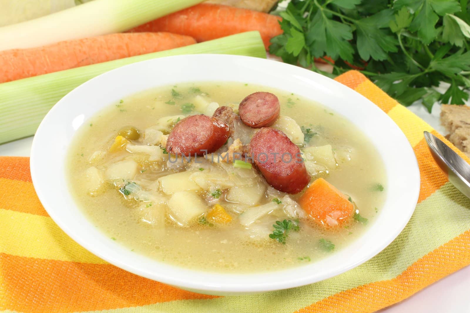 fresh white cabbage soup with vegetables, fried sausage and bread