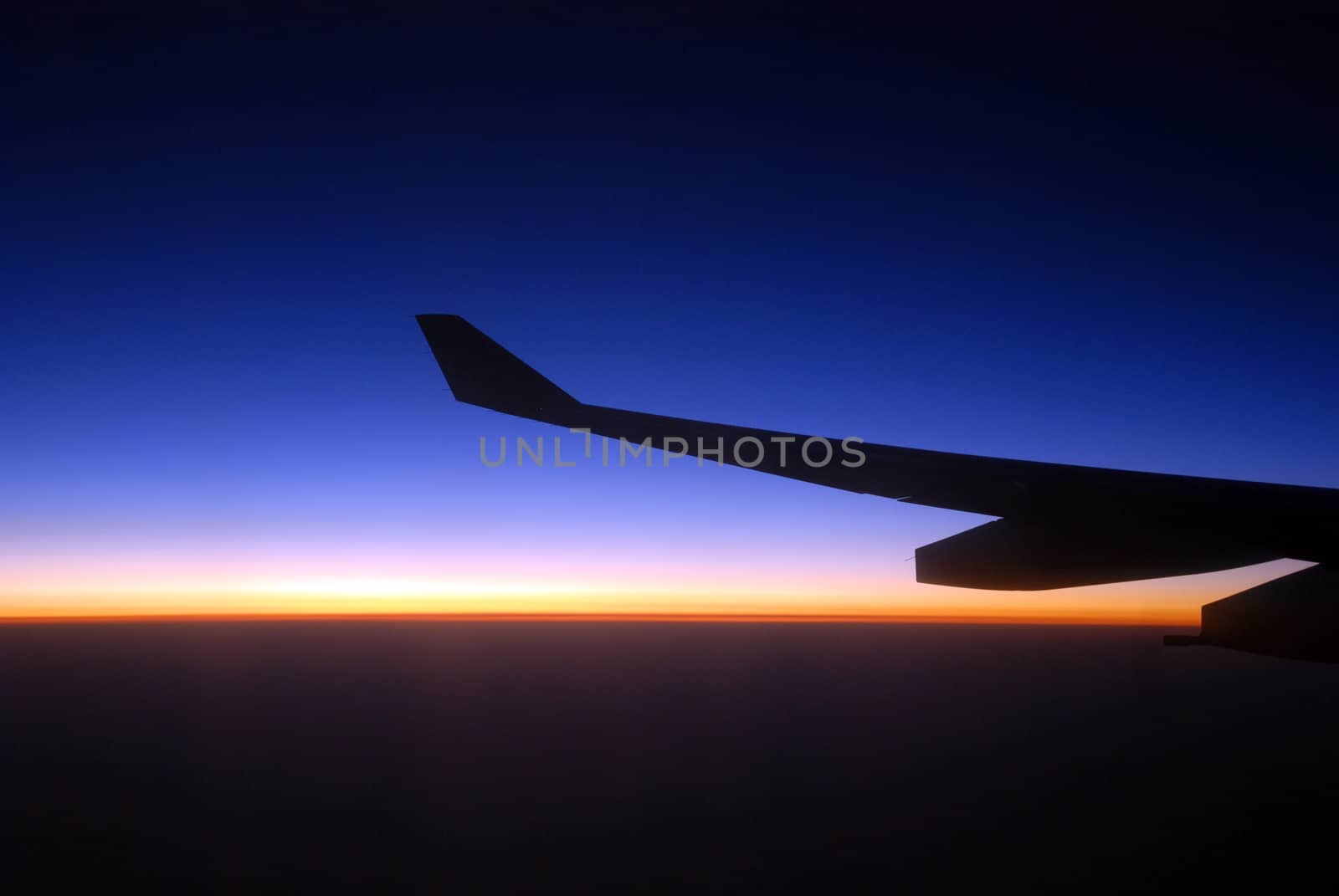 view from the airplane window at sunrise, with airplane wing 
