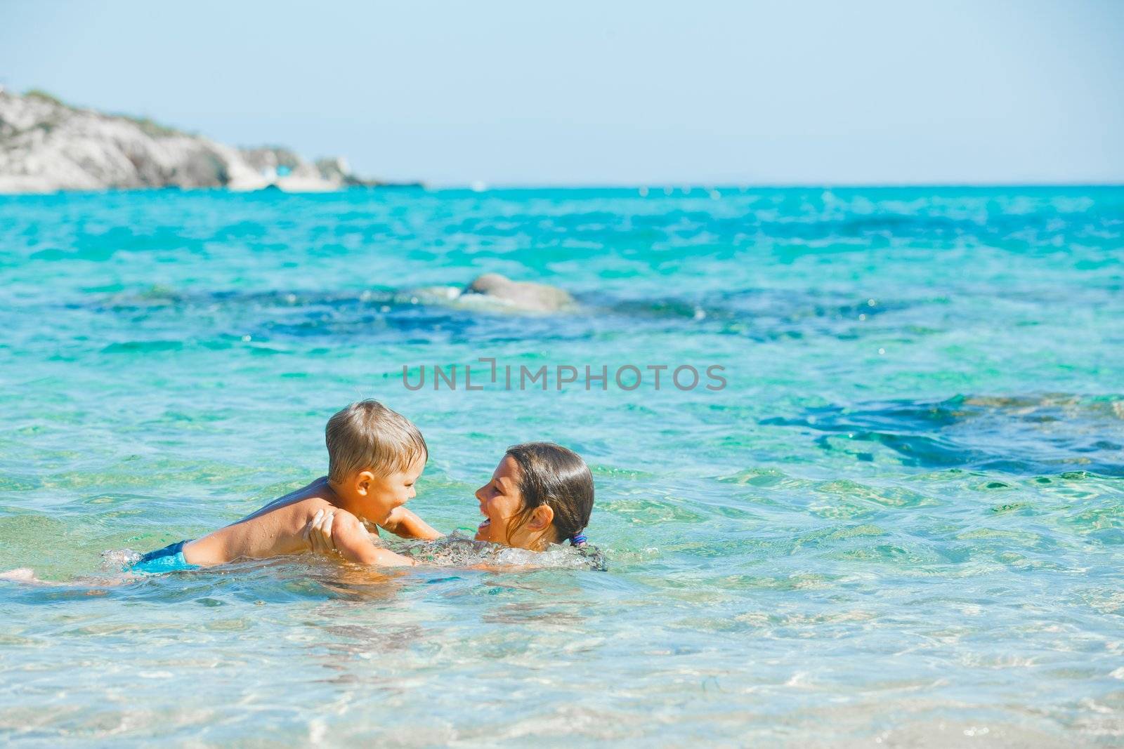 Happy kids. Sister and brother playing and swimming in the transparent sea