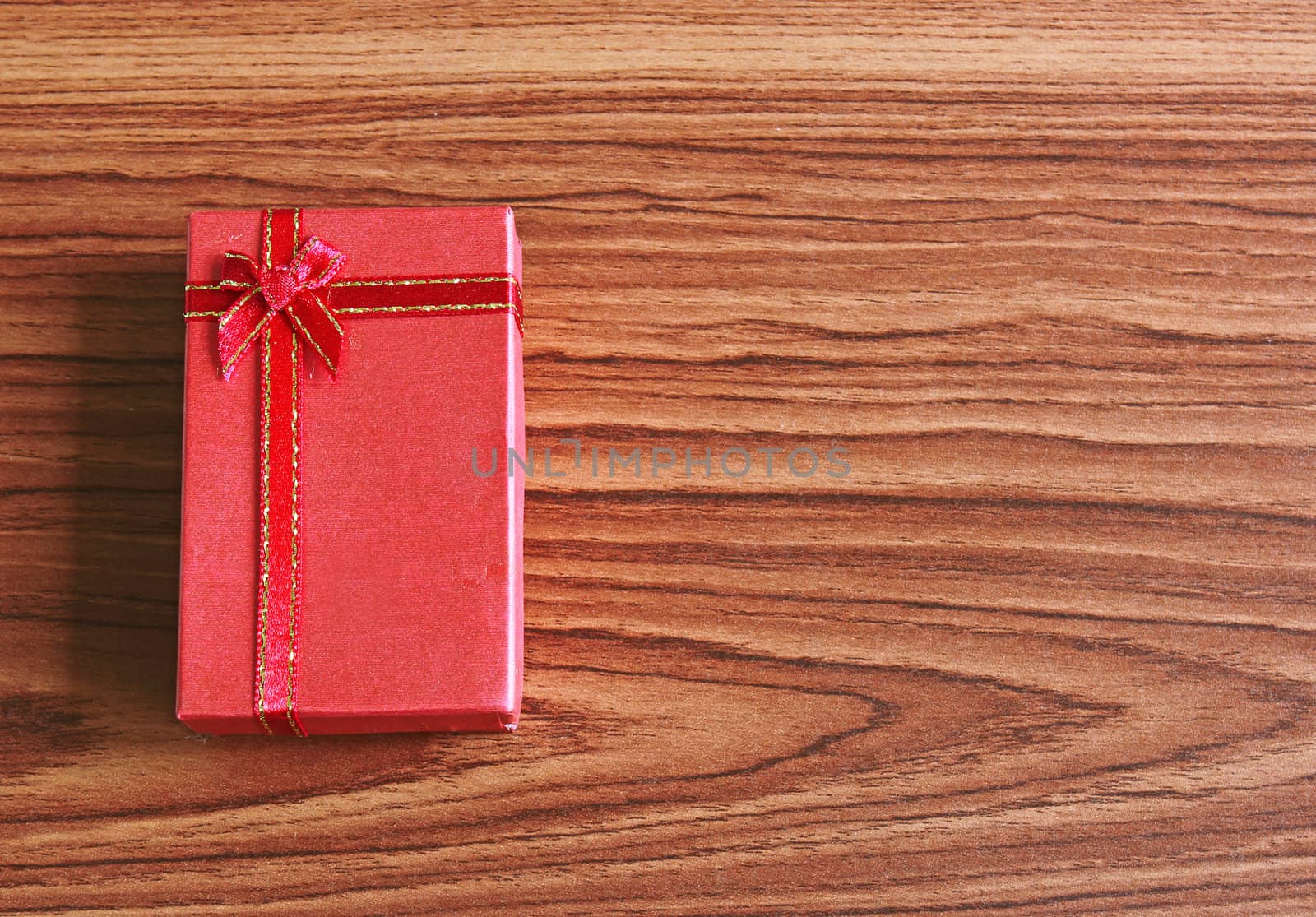 Red present box on wooden background 