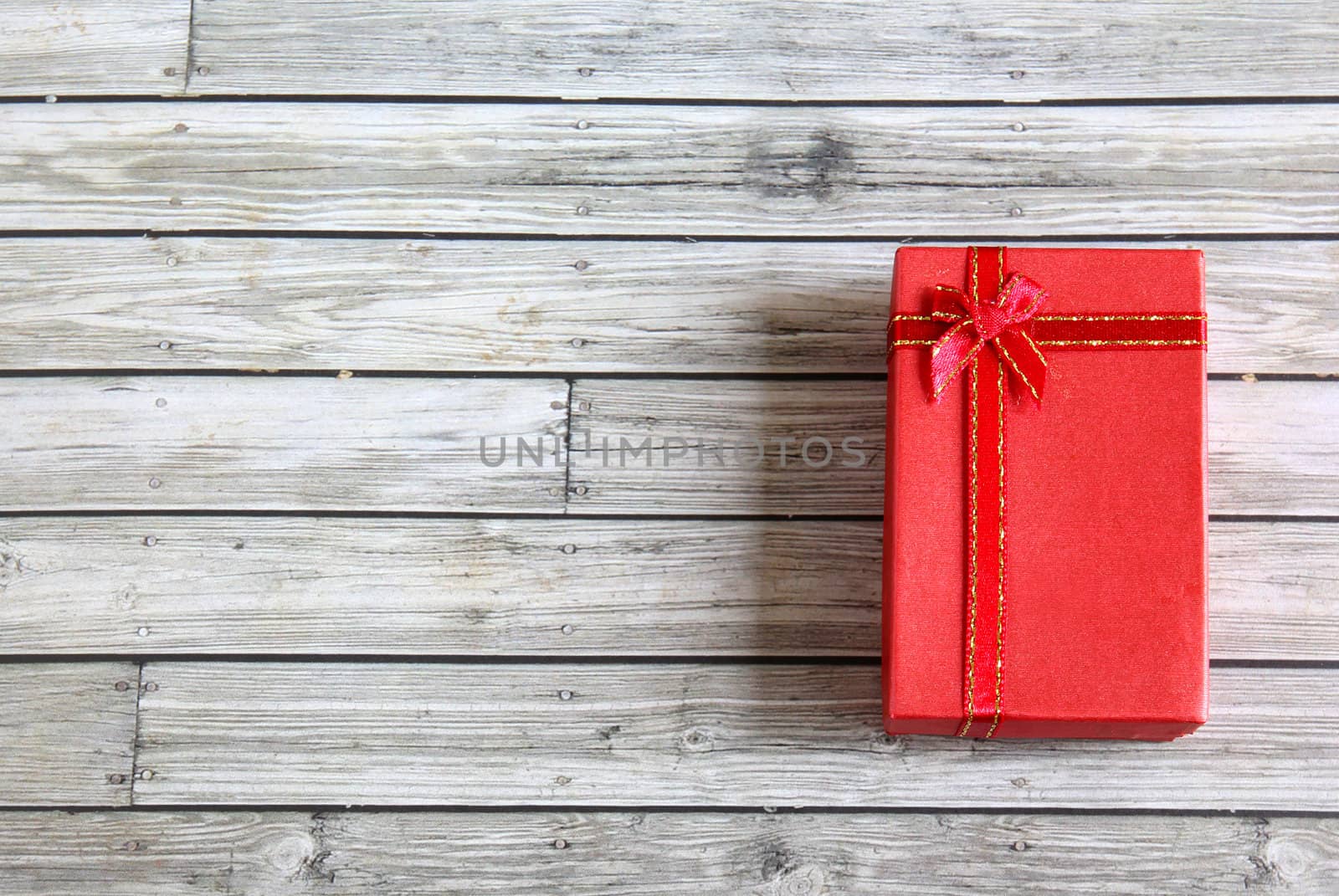 Red present box on wooden background 