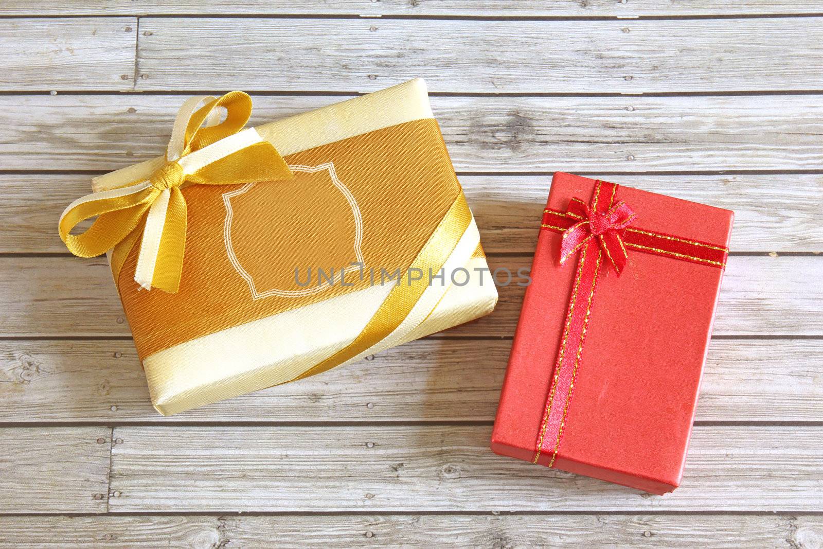 Gold and red present box on wooden background 