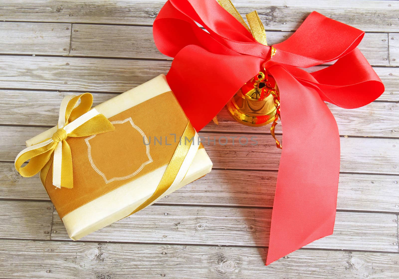 Gift box and red ribbon over wooden background 