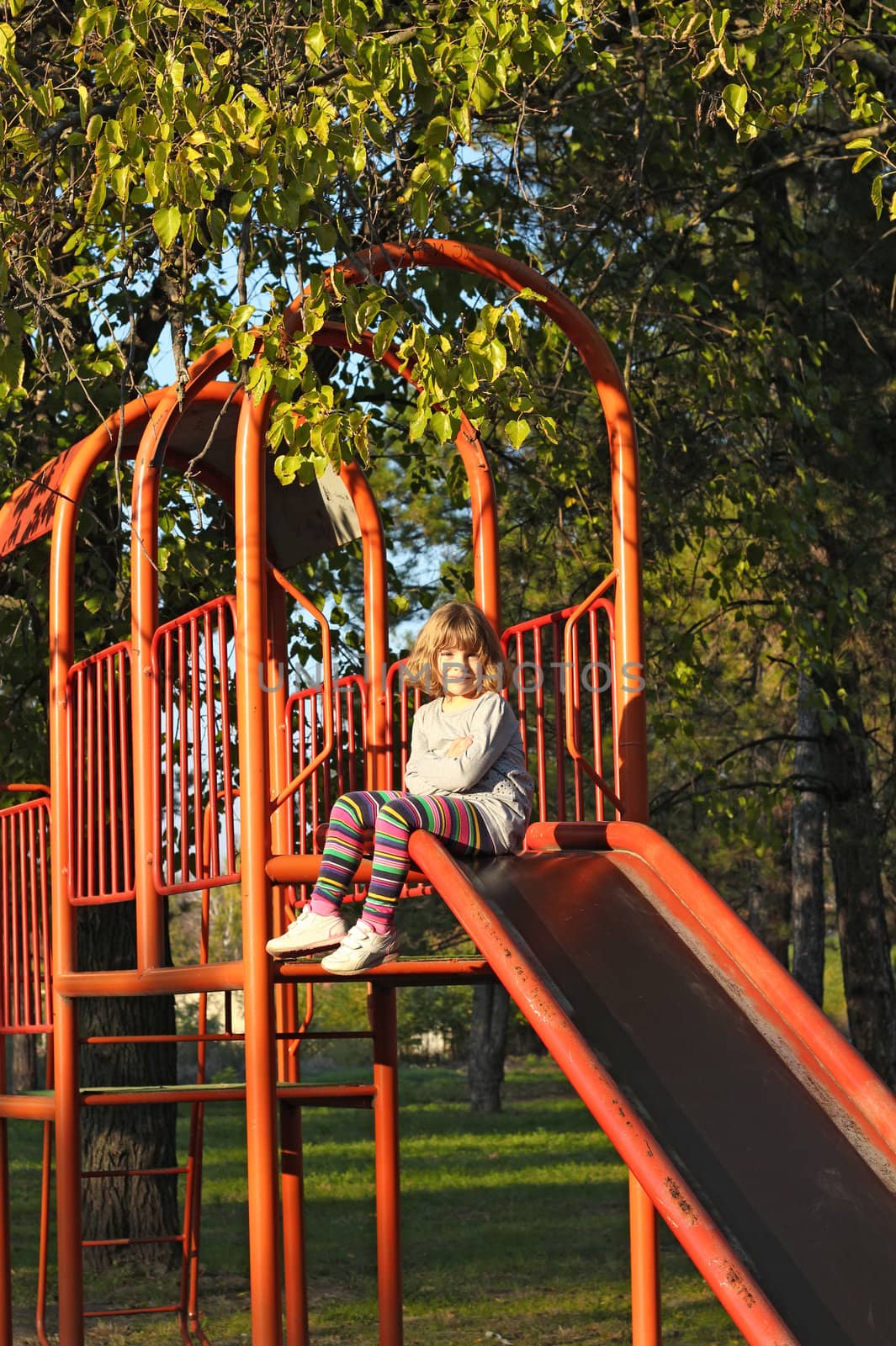 little girl on playground slide by goce
