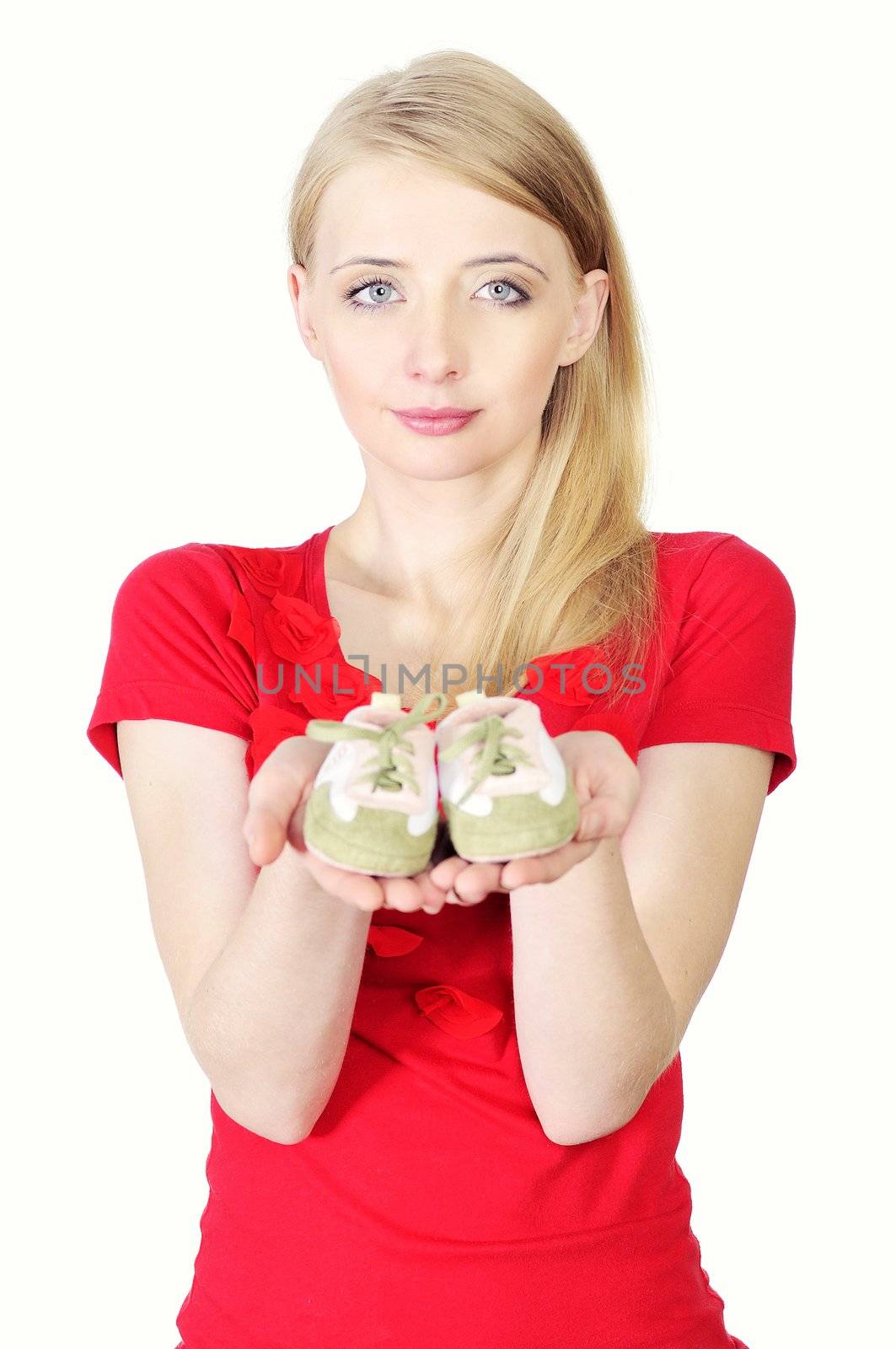 Woman holding baby shoes showing she is pregnant
