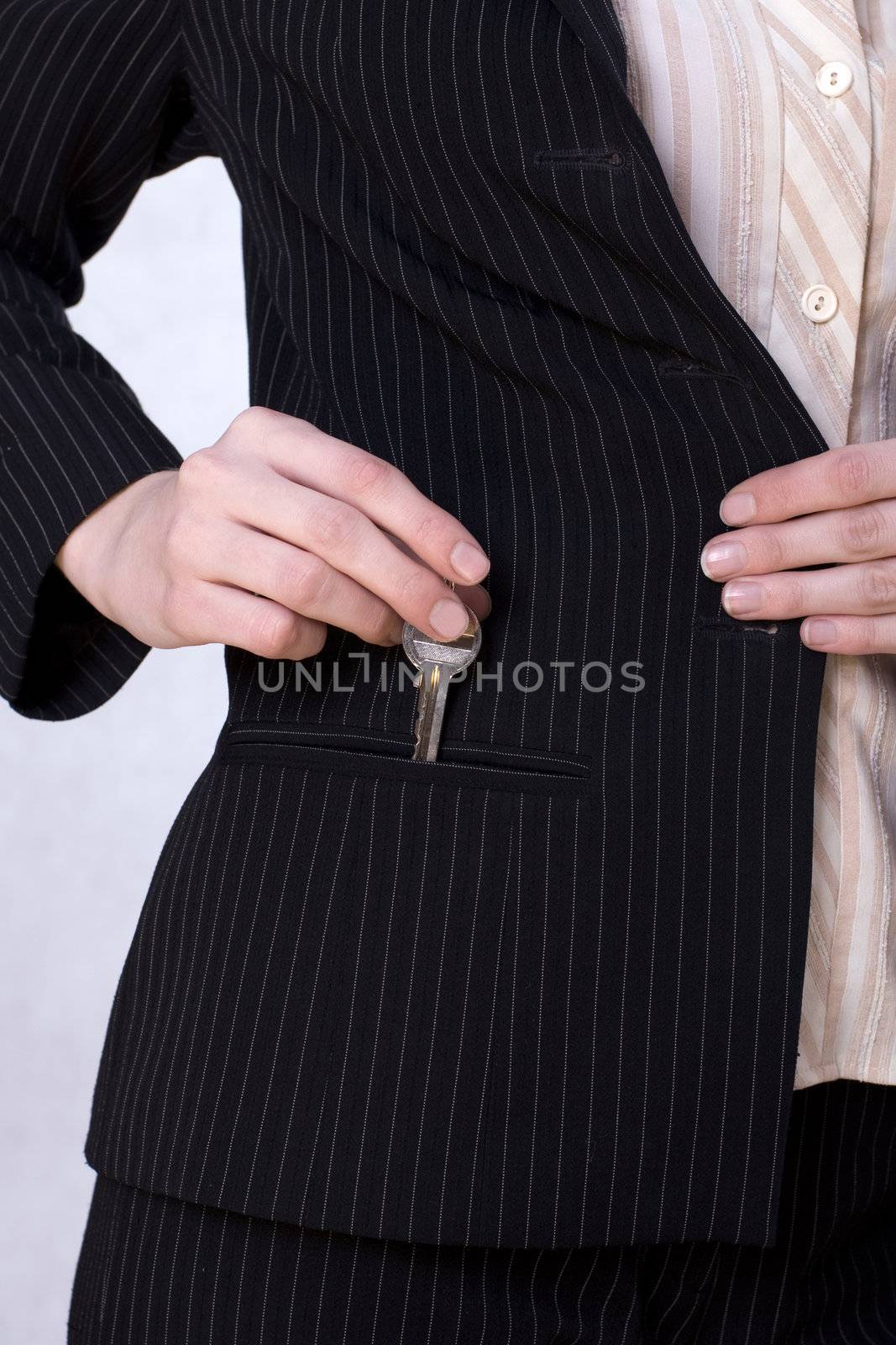 Businesswoman putting a key into her pocket