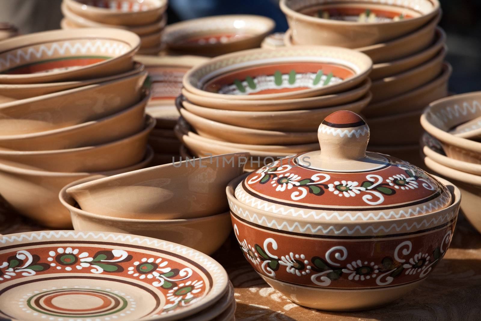 Rustic handmade ceramic pot and clay brown pottery decorated by traditional ornament and pattern at the handicraft market