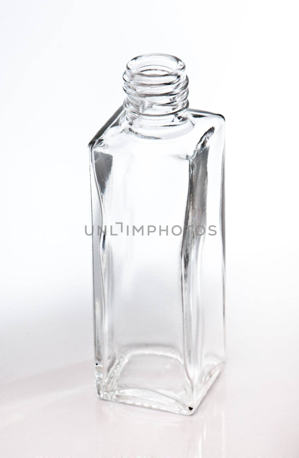 empty glass perfume bottle over a light backgroung