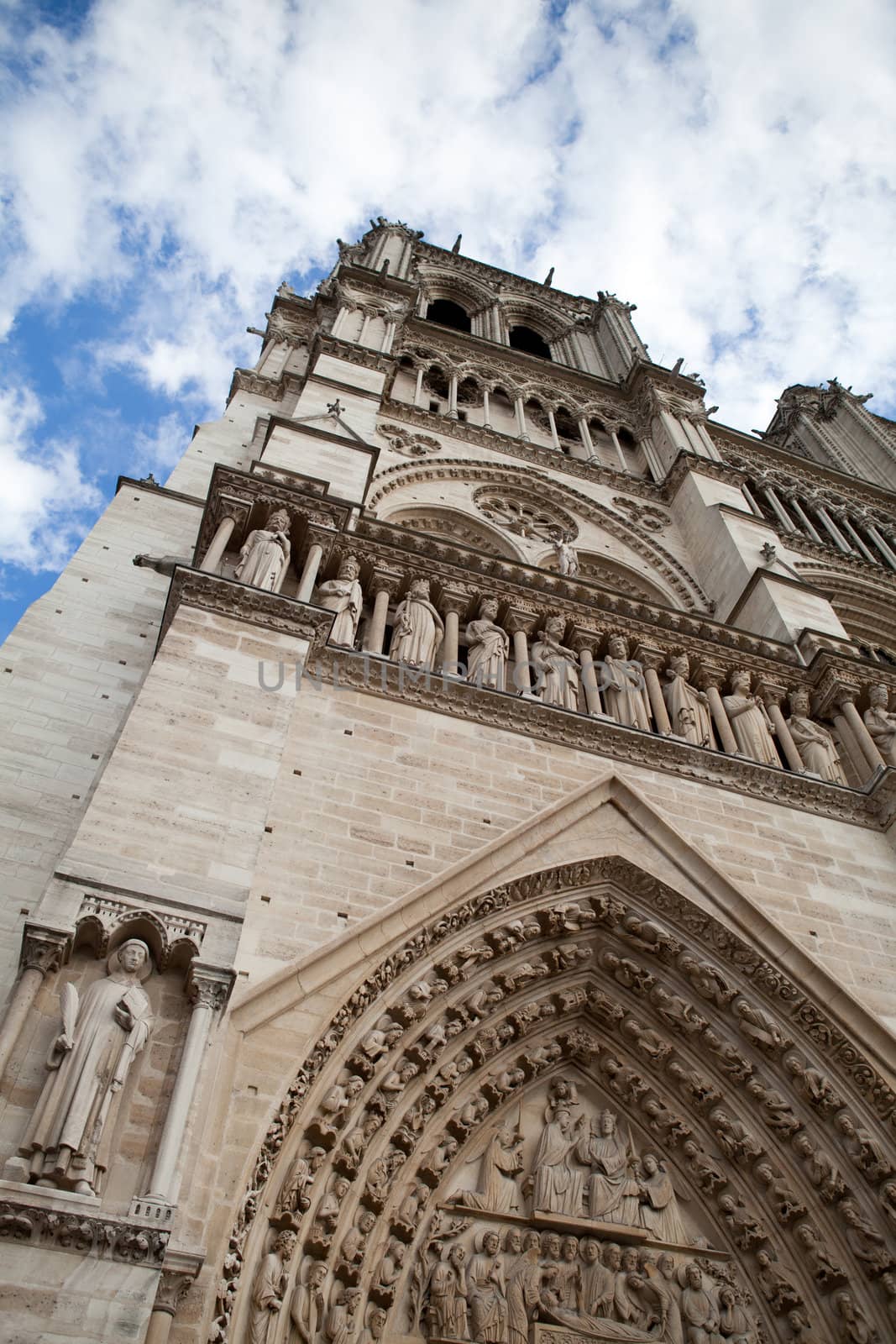 Famous landmark Gothic catholic cathedral Notre-dame on Cite island in Paris France on the blue and cloudy sky background