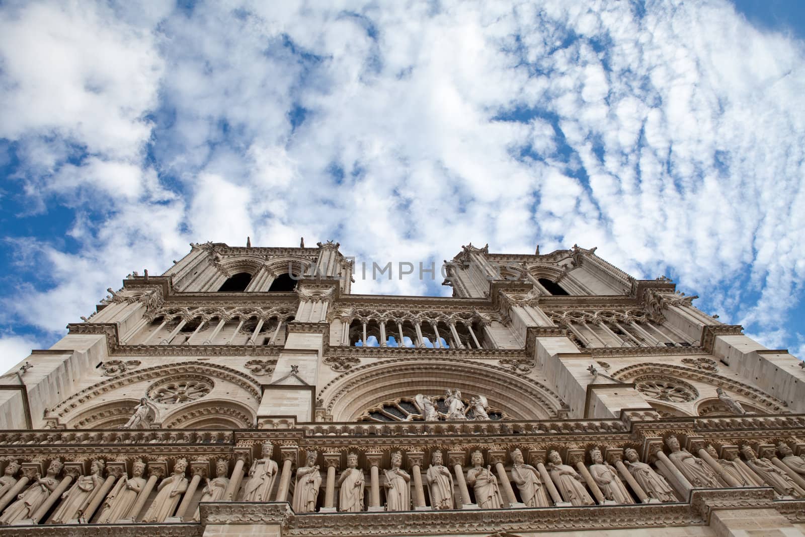 Famous landmark Gothic catholic cathedral Notre-dame on Cite island in Paris France on the blue and cloudy sky background