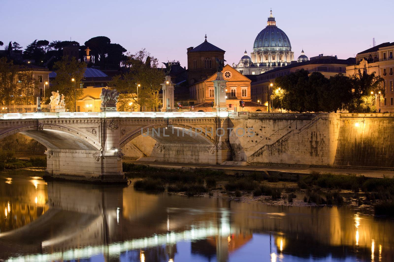 Cityscape of Saint Peter's basilica Vatican Rome Italy and Vittorio Emanuele bridge on Tiber bank in twilight