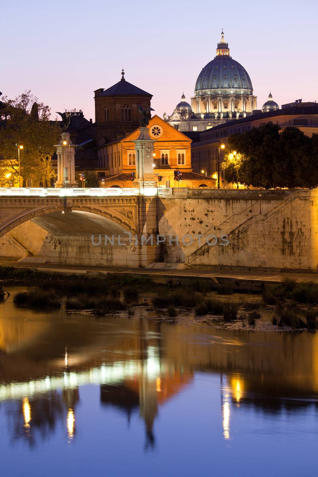 Cityscape of Saint Peter's basilica Vatican Rome Italy and Vittorio Emanuele bridge on Tiber bank in twilight