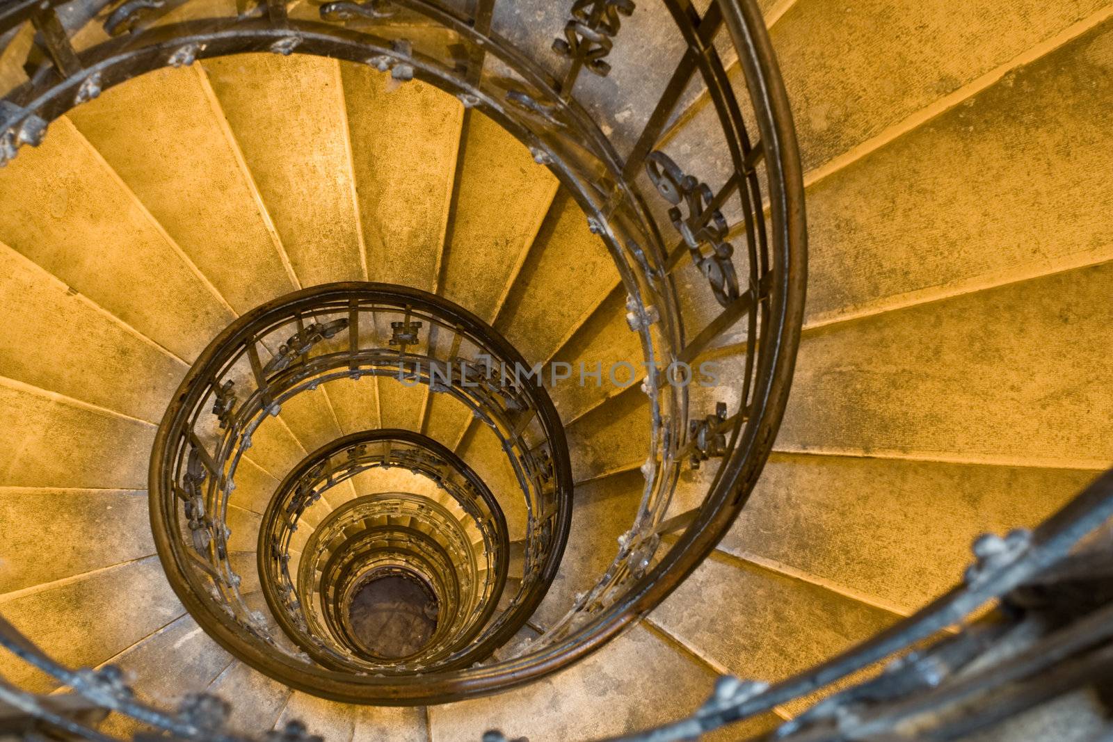 Spiral staircase, forged handhold and stone steps in old tower