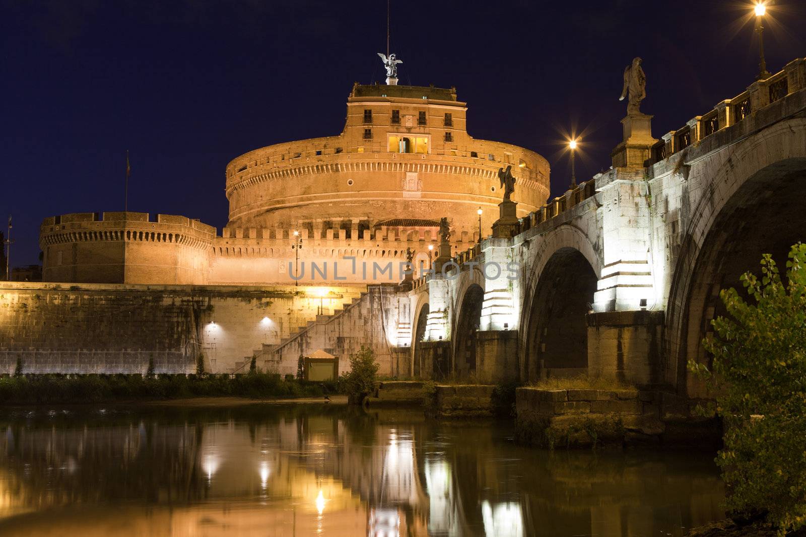 Tiber bank, arch stone bridge and reflection, museum, ancient Adrian mausoleum and medieval castle Saint Angel with statue archangel Michael  in Rome Italy at twilight