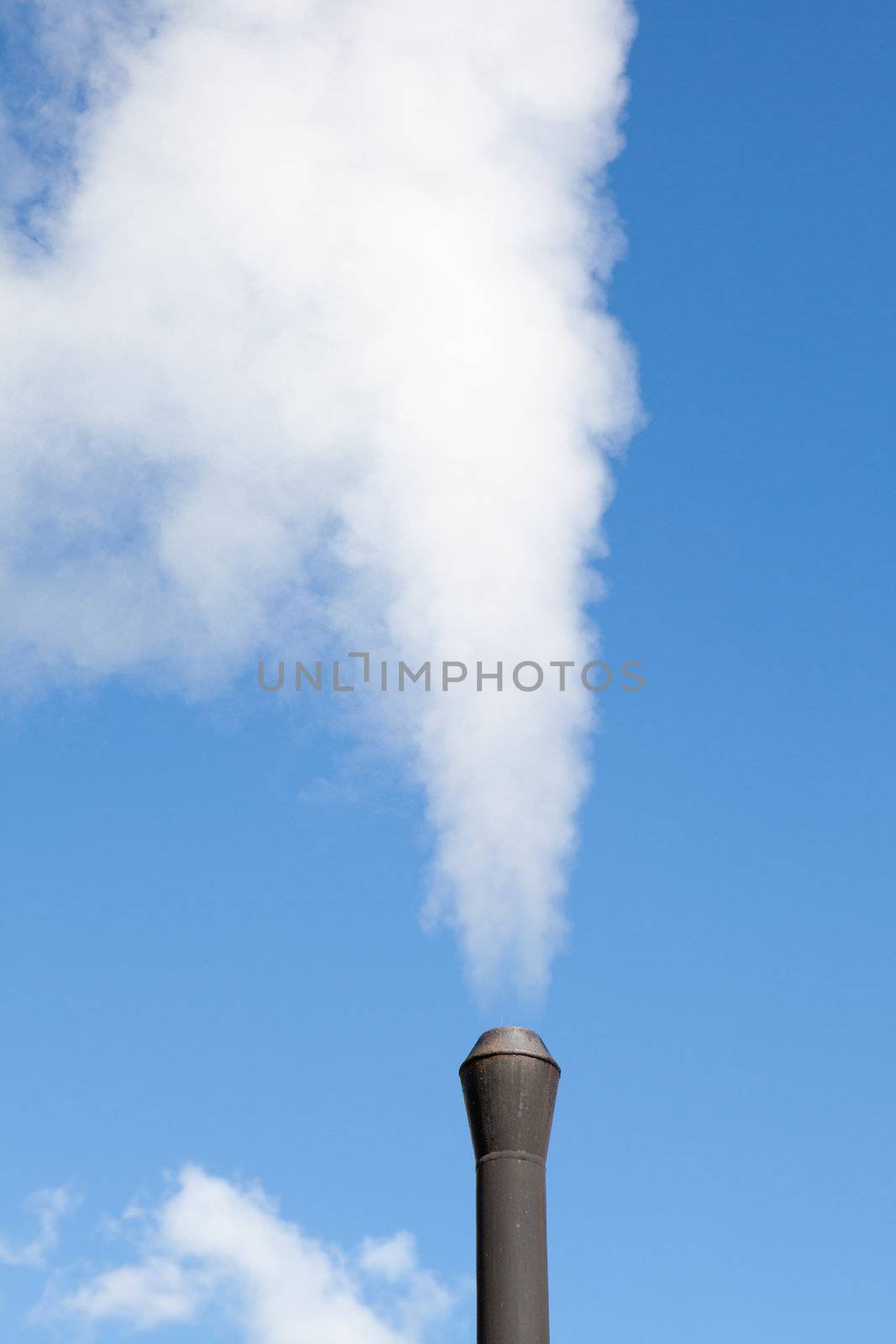 Industrial pipe polluting white steam on the blue sky background