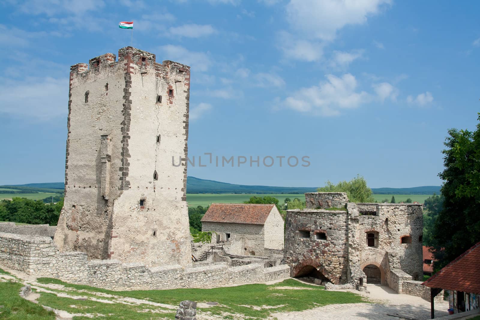 Medieval aged stone Kinizsi castle and tower in Nagyvazsony, Hungary on the blue sky background and countryside surroundings