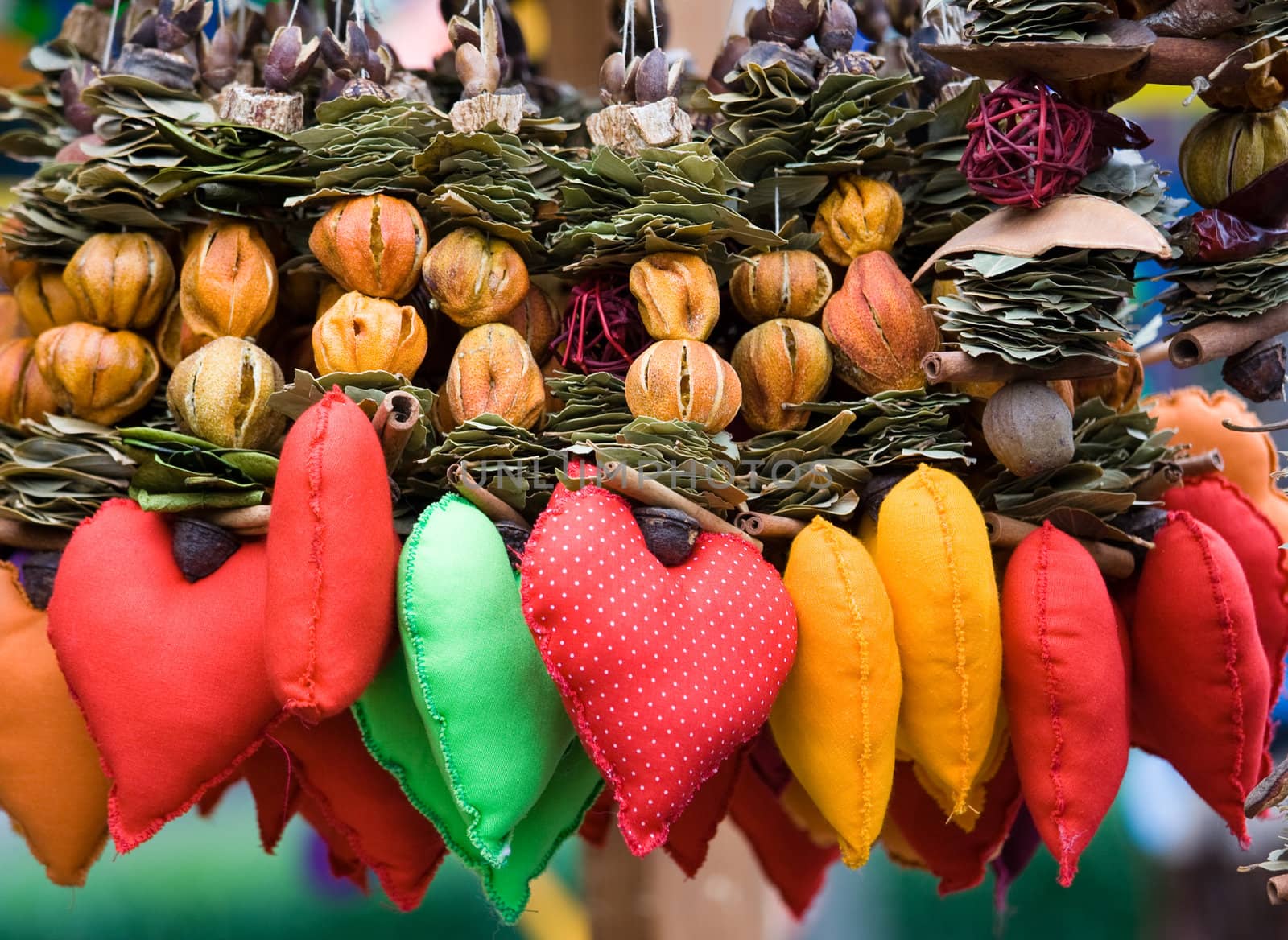 Red in spots heart among strings of dried fruits, leaves. Handicraft decor, souvenir for Valentine’s day.