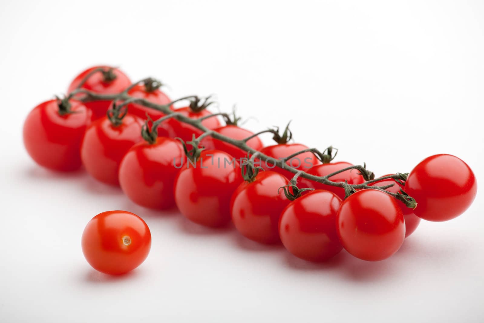 Cluster of fresh ripe red cherry tomatoes close-up on white background