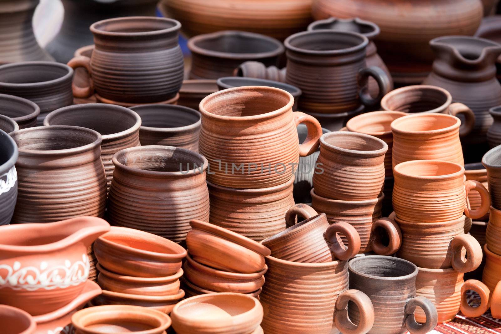 Rustic handmade ceramic clay brown terracotta cups souvenirs at street handicraft market