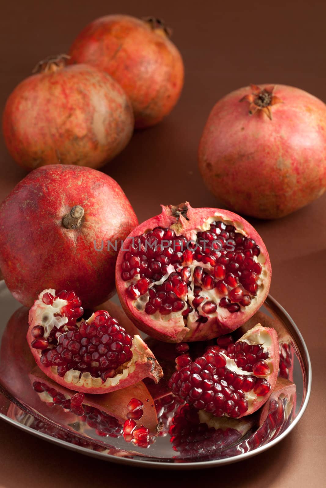 Pomegranate slices and seeds on silver salver