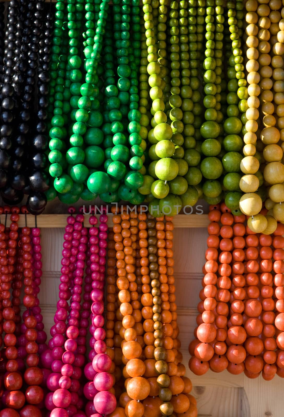 Showcase of handicraft wooden many-colored beads on the craft market close-up