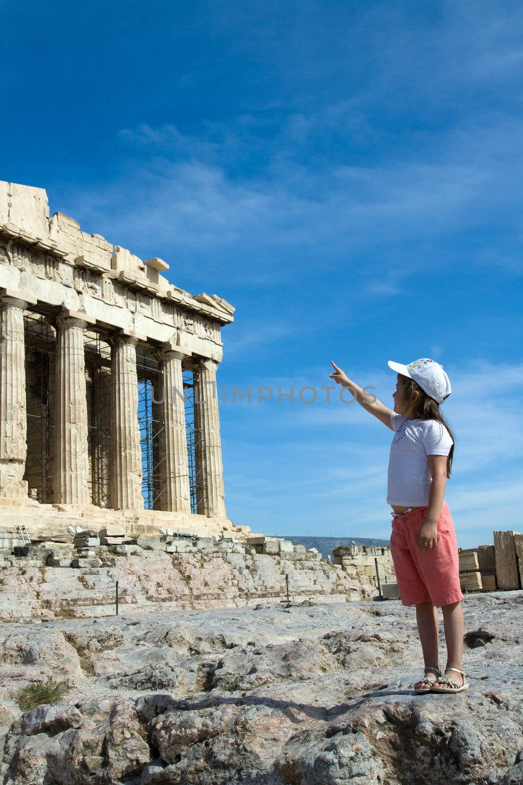 Little Child points to Facade of ancient temple Parthenon in Acropolis Athens Greece on the blue sky background