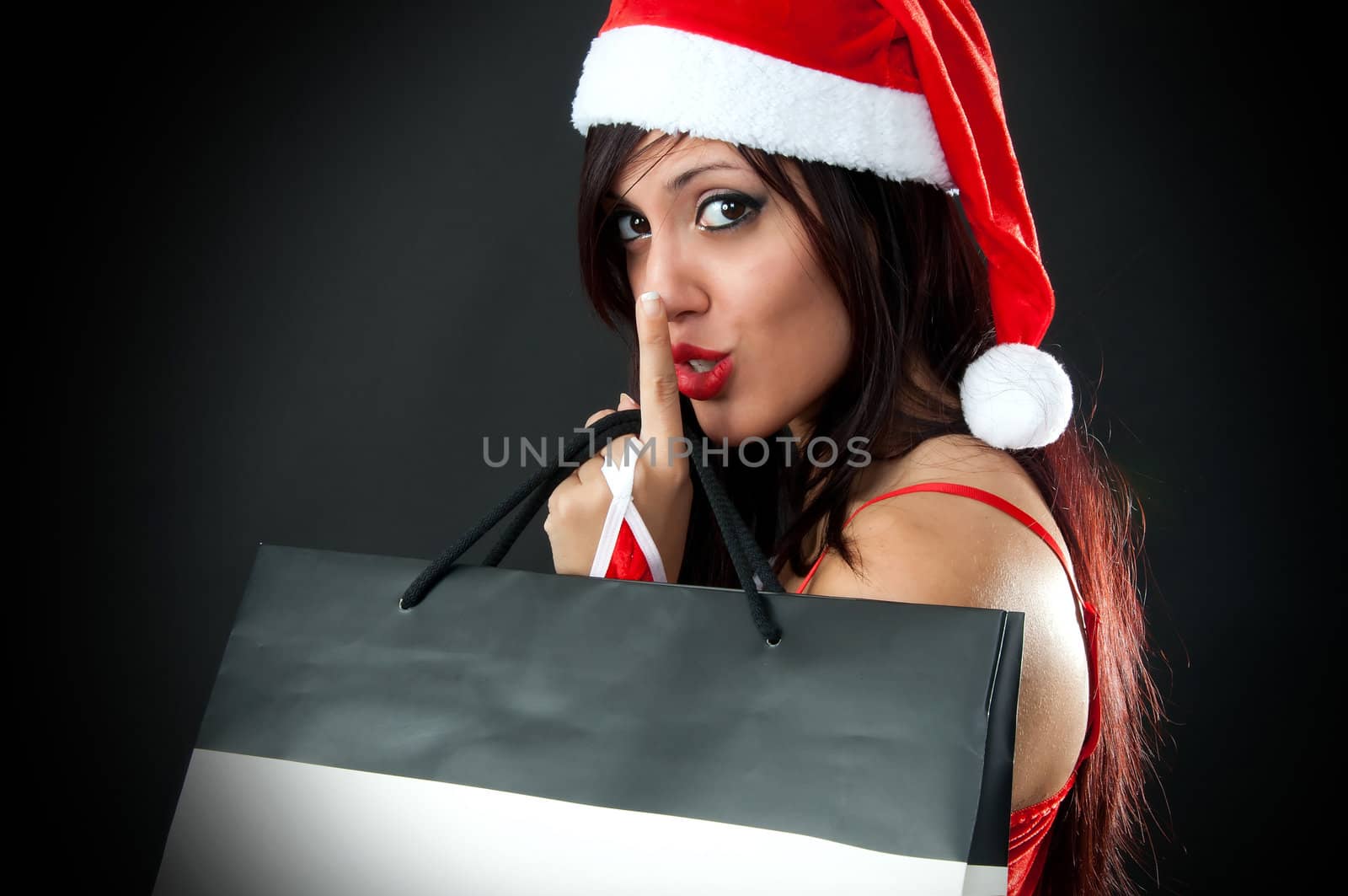 Portrait of Beautiful sexy girl wearing santa claus clothes with shopping bag say sssshhhhh