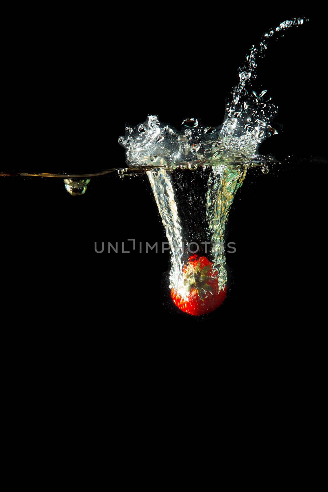 Colored red paprika in water splashes on black background