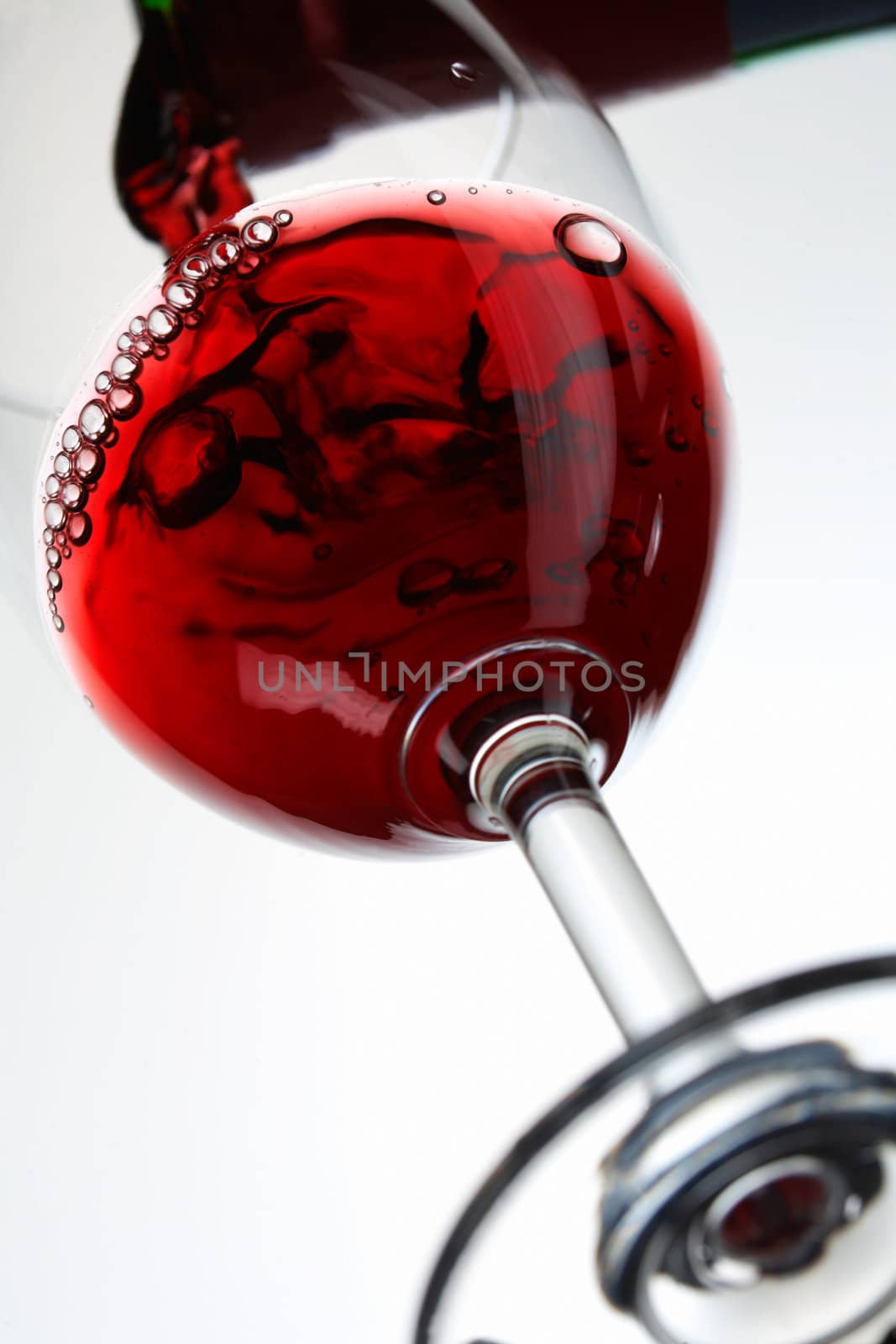 Red wine pour in a glass on white background