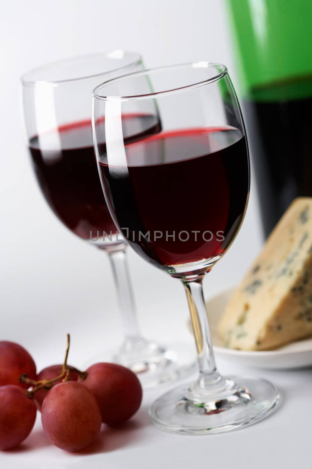 Red wine, grape  and cheese in the background 