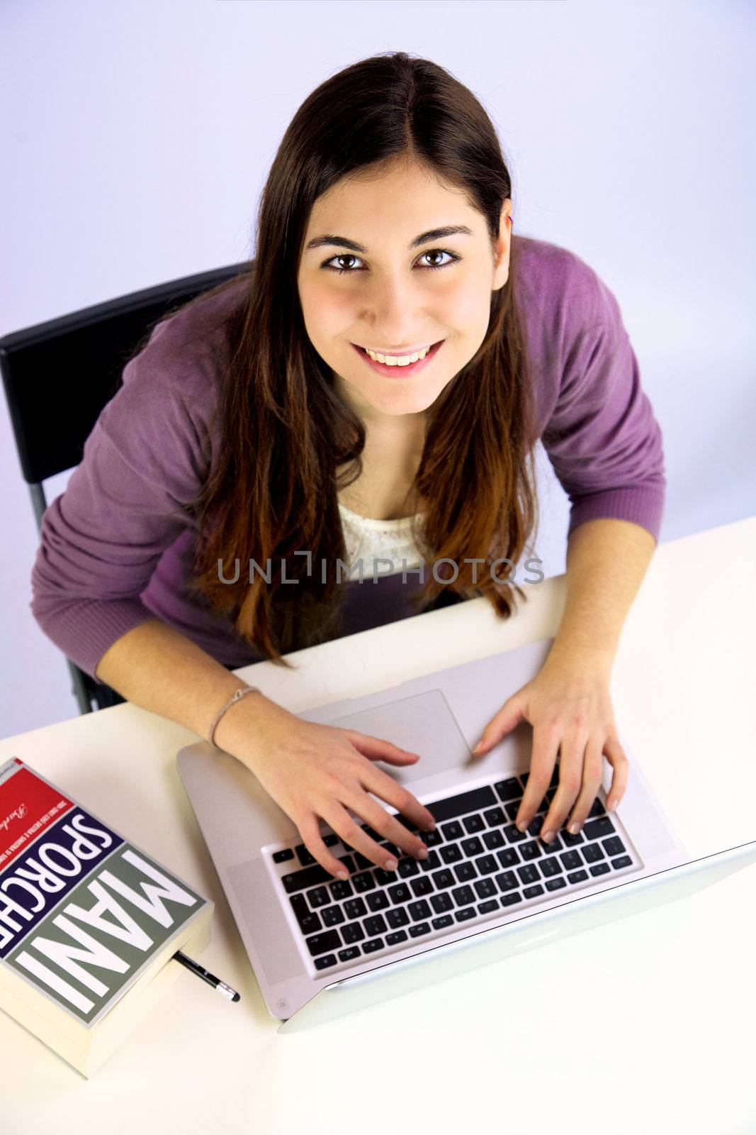 Cute young woman with long hair studying with computer 