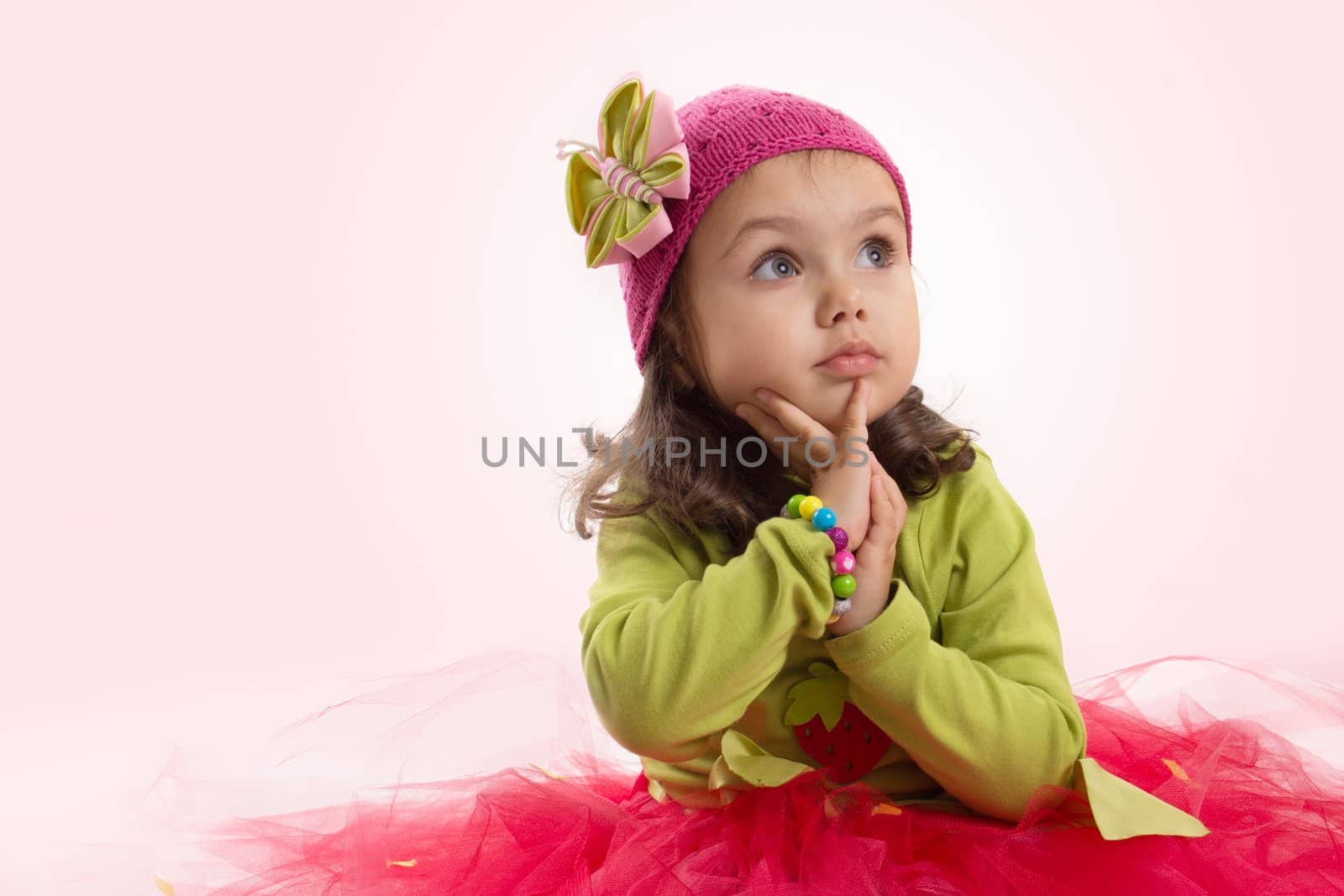 Adorable girl in tutu and hat with butterfly over pink