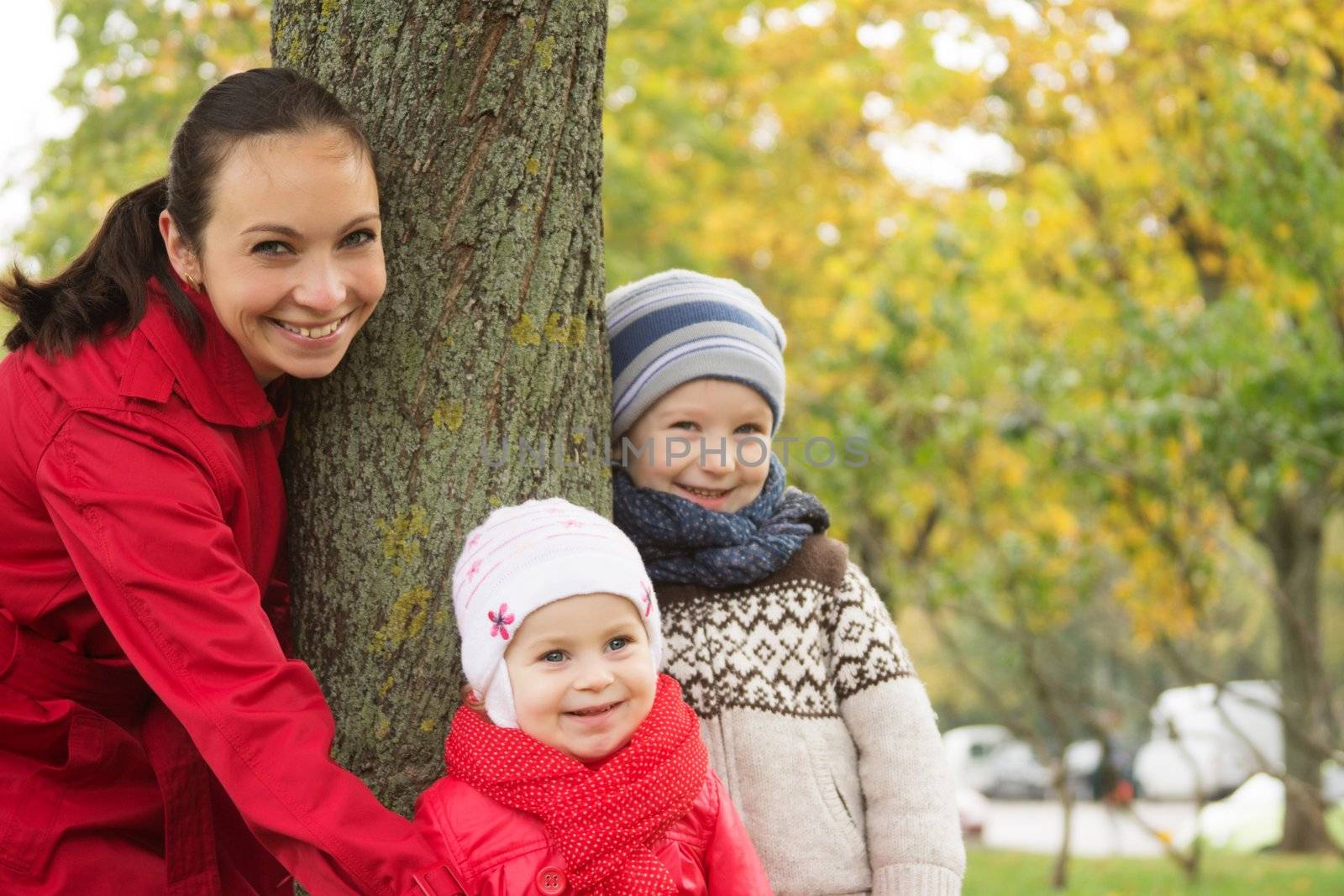 Happy mother and two children in autumn park