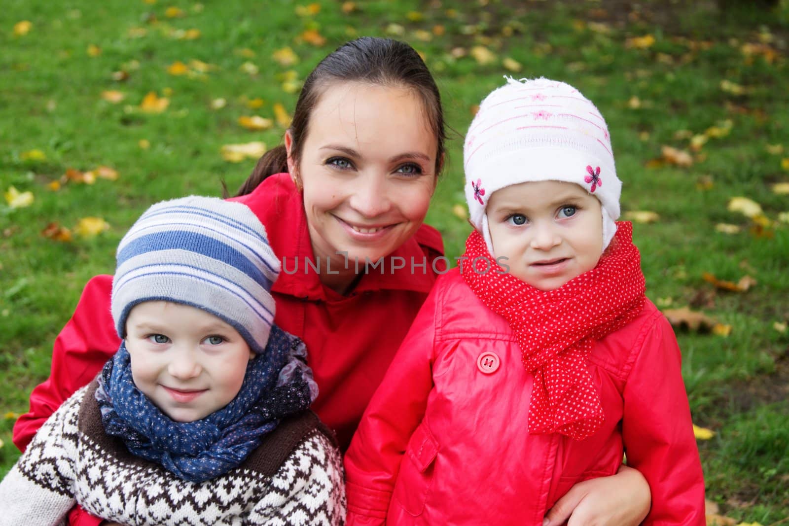Happy mother and two children in autumn park