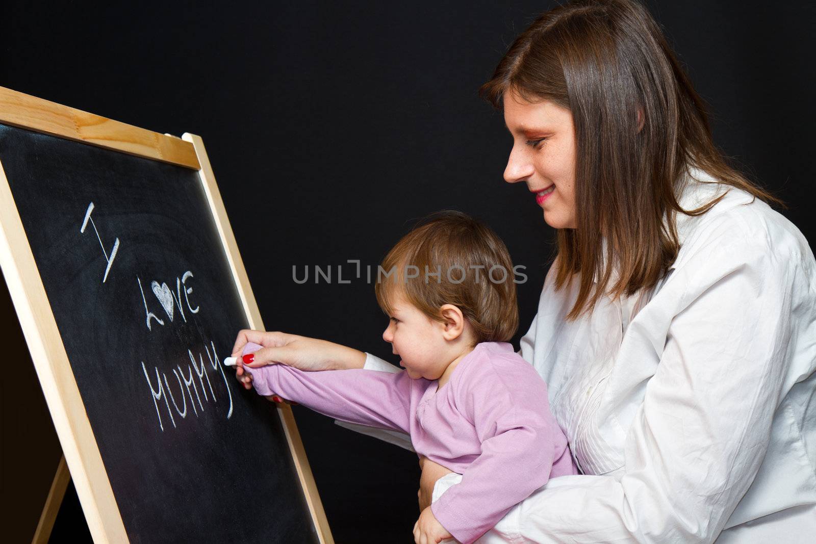 Mother and little daughter writing on a blackboard
