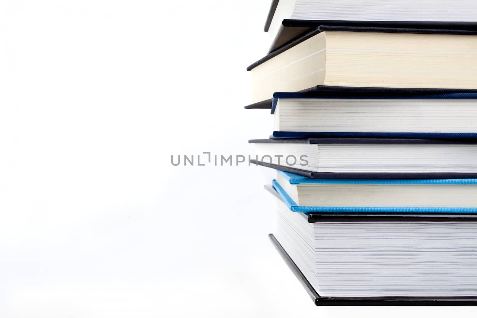 An abstract shot of a pile of books over a white background.