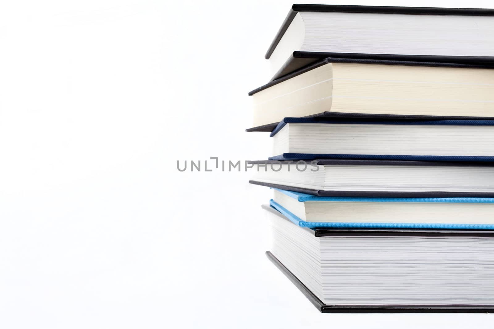 An abstract shot of a pile of books over a white background.