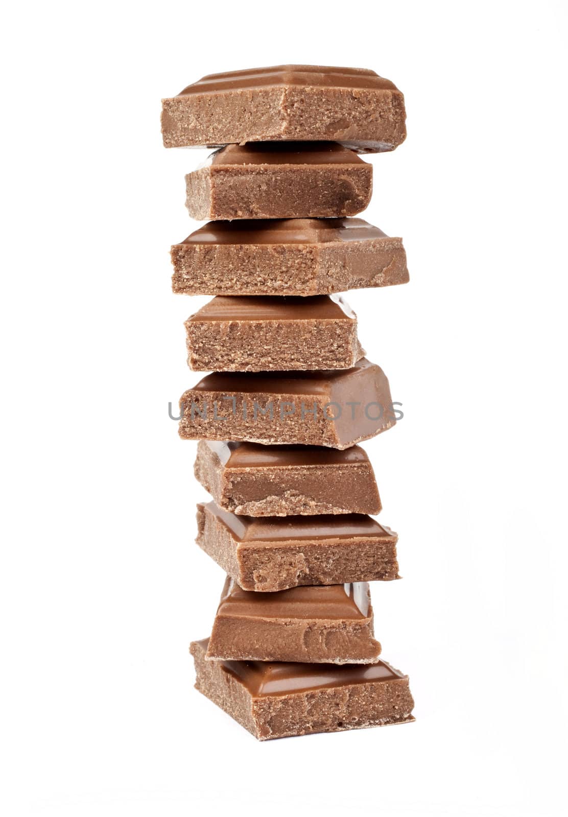Chunks of Chocolate piled up in front of a white background.